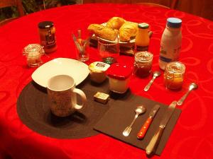 a table with a red table cloth with a plate of food at Chez Marie et Gégé in Puyréaux