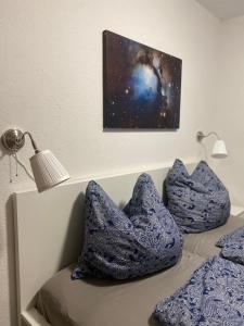 ein Schlafzimmer mit zwei blauen Kissen auf einem Bett in der Unterkunft Regenbogengasse in Schkeuditz