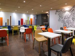 une salle à manger avec des tables et des chaises colorées dans l'établissement ibis budget Albertville, à Gilly-sur-Isère
