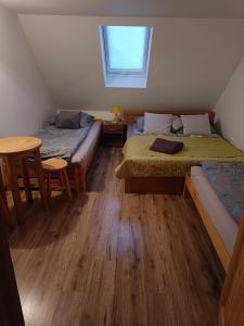 Habitación con 2 camas, mesa y ventana en Farcik Apartament en Nowa Wieś