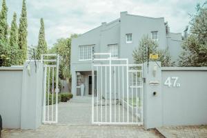 a white gate in front of a white house at Private luxurious 3 bedroom complete house in Bloemfontein