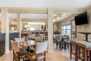 a restaurant with tables and chairs and a bar at Quality Inn Amsterdam Fredericton in Fredericton