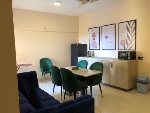 a waiting room with a table and green chairs at Hamsun Apart Hotel Clifton in Karachi
