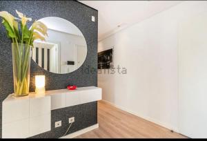 a bathroom with a mirror and a vase on a counter at Riverside - apartment in Cruz Quebrada
