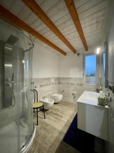 a bathroom with two sinks and a shower and two toilets at San Leonardo Country House in Calangianus