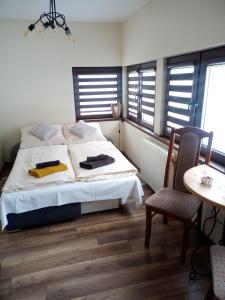 Apartament Karamba في شكلارسكا بوريبا: غرفة نوم بسرير وطاولة وكراسي