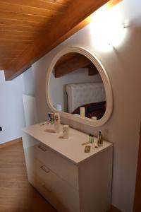 uma casa de banho com um toucador e um espelho redondo em B&B Alina em Catanzaro Lido