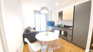 a kitchen with a white table and chairs in a room at Seven Seas Luxury Apartments - Bari San Girolamo in Bari