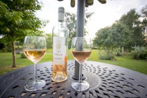 dos vasos de vino blanco sentados en una mesa en West Cottage, Southlands Farm, Gunnerton en Hexham