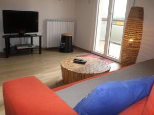 een woonkamer met een bank, een tafel en een tv bij Serene Holiday Home in Lazise with Swimming Pool in Lazise