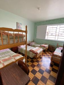 a bedroom with four bunk beds and a checkered floor at Pousada Irmãs Franciscanas in Lages