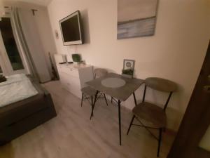 sala de estar con mesa y sillas en una habitación en Luxusní apartmán Rezidence 1351, en Pardubice