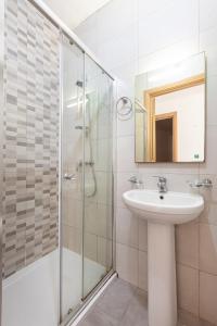 een badkamer met een wastafel en een douche bij Corner view apartment in St Paul's Bay