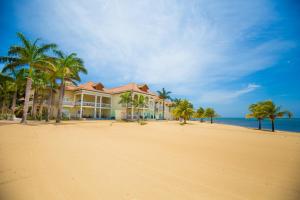 una casa en una playa con palmeras y el océano en Lawson Rock - Angelfish 100 Condo, en Sandy Bay