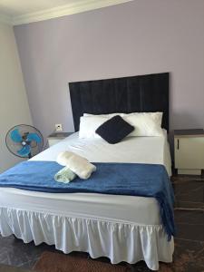 Un dormitorio con una cama grande con cabecero negro. en Olivia's guest house, en Ciudad del Cabo 21 fotos más