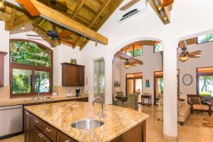 a kitchen with a sink and a living room at Chula Vista Home in West Bay