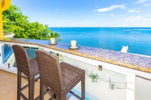 2 sillas sentadas en un balcón con vistas al océano en Del Playa Penthouse #6 Condo, en West End