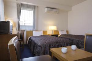 Giường trong phòng chung tại Sankei City Hotel Hachioji