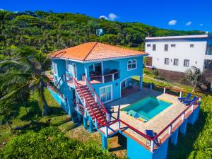 an aerial view of a blue house with a swimming pool at Oceanfront Coral View Home in West Bay