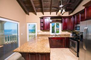 a kitchen with wooden cabinets and a counter top at Oceanfront Coral View Home in West Bay