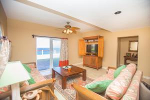 a living room with a couch and a tv at Oceanfront Coral View Home in West Bay