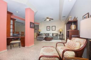 a living room with pink walls and a couch at Lawson Rock - Seahorse 105 condo in Roatan