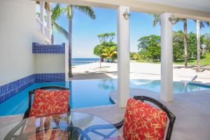 a glass table and chairs with a view of the ocean at Lawson Rock - Angelfish 101 condo in Roatán
