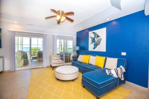 sala de estar azul con sofá y ventilador de techo en Lawson Rock - Angelfish 203 Condo, en Sandy Bay
