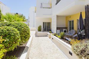 a courtyard of a house with plants and a patio at Fisherman 21 - Cabanas Beach in Cabanas de Tavira