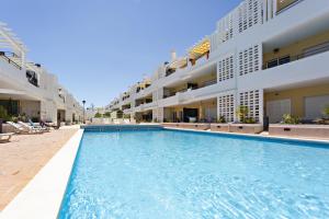 una piscina frente a algunos edificios de apartamentos en Fisherman 21 - Cabanas Beach en Cabanas de Tavira