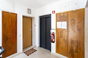 a hallway with two doors and a fire extinguisher at Fisherman 21 - Cabanas Beach in Cabanas de Tavira +14 photos