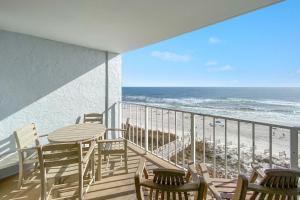 uma varanda com mesa e cadeiras e a praia em Sunswept 702 condo em Orange Beach