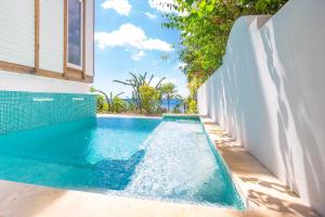 een zwembad aan de zijkant van een huis bij Stunning views at - Villa Aire apts in Roatan