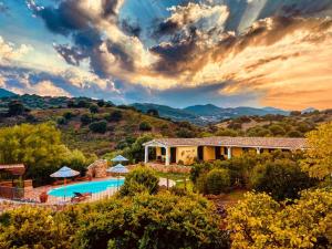 a villa with a swimming pool and a house at Oasi Muru Idda in Budoni