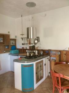 cocina con fogones y mesa. en Casalado, en El Saltador Bajo