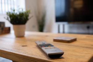 a remote control sitting on top of a wooden table at Hazel House in West Bromwich
