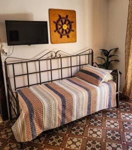 1 dormitorio con 1 cama y TV en la pared en Appartamento Porto Marina VA1, en Licata