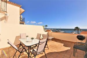 une terrasse avec une table et des chaises et l'océan dans l'établissement Townhouse TOBY, à Estepona