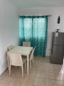 eine Küche mit einem Tisch und Stühlen sowie einem Kühlschrank in der Unterkunft Hanas paradise in San Felipe de Puerto Plata