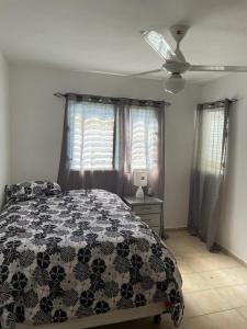 a bedroom with a bed and a ceiling fan at Hanas paradise in San Felipe de Puerto Plata