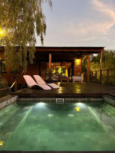 a swimming pool in front of a house at Eco Cabaña Río - Cabaña Mirador in Tigre