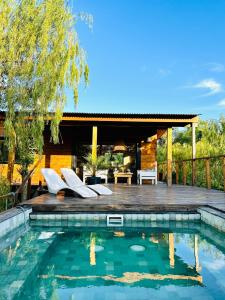 un patio trasero con piscina y terraza de madera en Eco Cabaña Río - Cabaña Mirador en Tigre