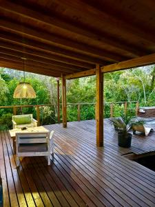 a wooden deck with a couch and a table at Eco Cabaña Río - Cabaña Mirador in Tigre