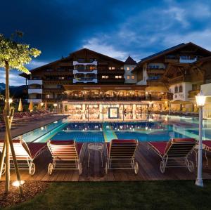 a view of the pool at a resort at night at Alpenpark Resort Superior in Seefeld in Tirol