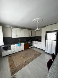 a kitchen with white cabinets and a refrigerator at Garden House in Istanbul