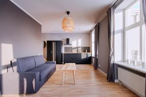 Modern apartment in Old Riga with a river view في ريغا: غرفة معيشة بها أريكة وطاولة