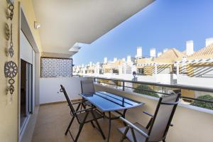 a balcony with a table and chairs on it at Ocean Breeze Apartment in Cabanas de Tavira