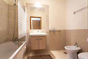a bathroom with a sink and a toilet and a tub at Ocean Breeze Apartment in Cabanas de Tavira +4 photos
