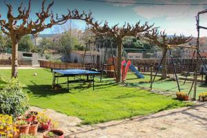 un parque infantil con una mesa y columpios en un patio en Casa Rural Espasa, en Espluga de Francolí