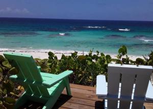 two chairs sitting on a deck looking at the beach at Serenity - Away From The Things Of Man... Lat23N.c in McKanns